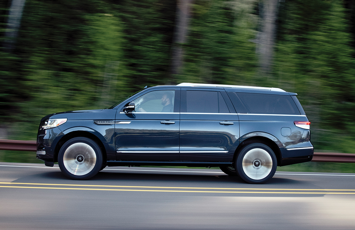 Lincoln Navigator SUV driving on forest road
